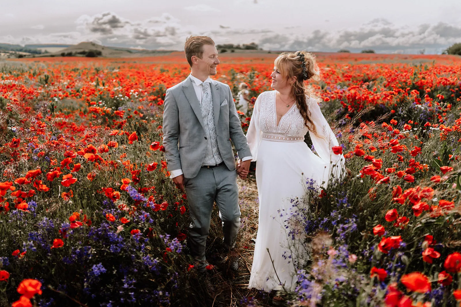 Brautpaar in einem bluehenden Mohnfeld, fotografiert von Kathrin Streuber