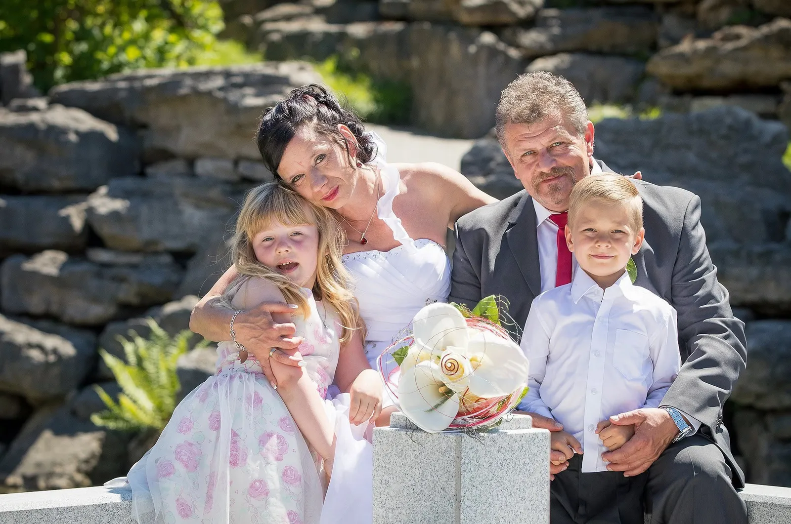 Brautpaar mit Kindern und Geschenken an der Steinmauer, Hochzeitsfotograf Sömmerda