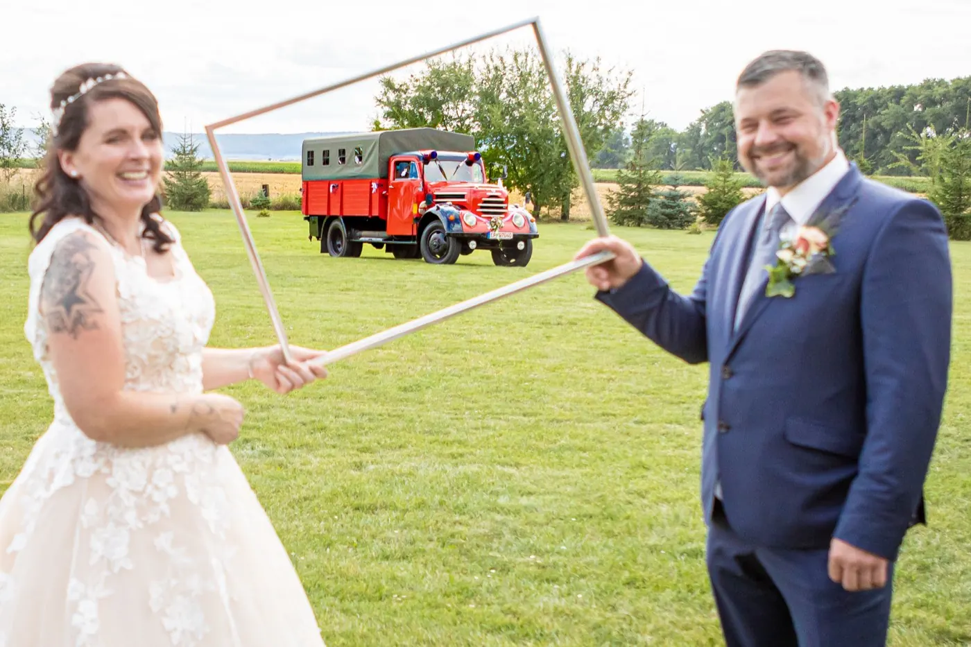 Brautpaar hält gemeinsam ein Strahlrohr der Feuerwehr, Hochzeit in Gebesee