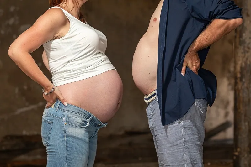 Humorvoller Vergleich im Profil, die Schwangere und ihr Partner strecken sich die nackten Bäuche entgegen, Babybauch Shooting Sömmerda Dirk Dittrich