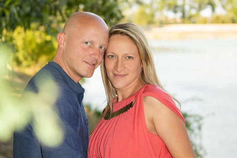 Paar lehnt Kopf an Kopf aneinander vor einem See im warmen Abendlicht, Familienfotograf Sömmerda Dirk Dittrich