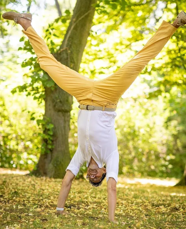 Mann im weißen Hemd und gelber Hose macht einen Handstand im herbstlichen Park, Portraitfotograf Sömmerda Dirk Dittrich