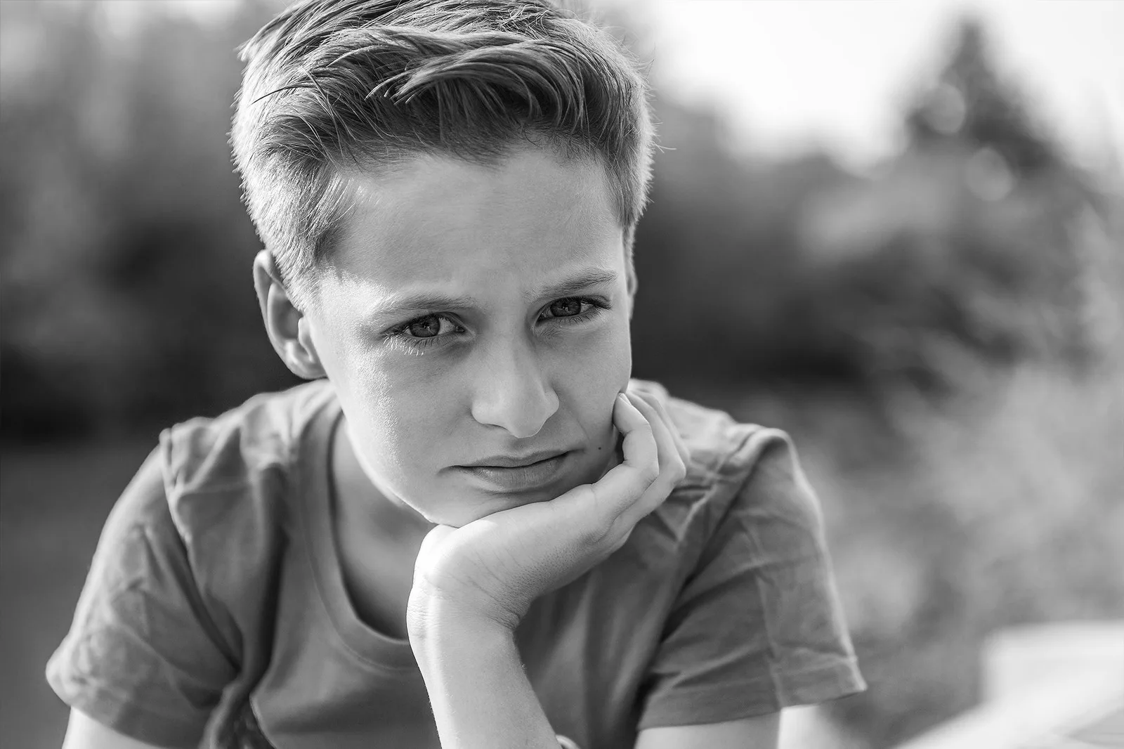 Schwarzweiß Portrait eines nachdenklichen Jungen mit aufgestütztem Kinn, Portraitfotograf Sömmerda Dirk Dittrich