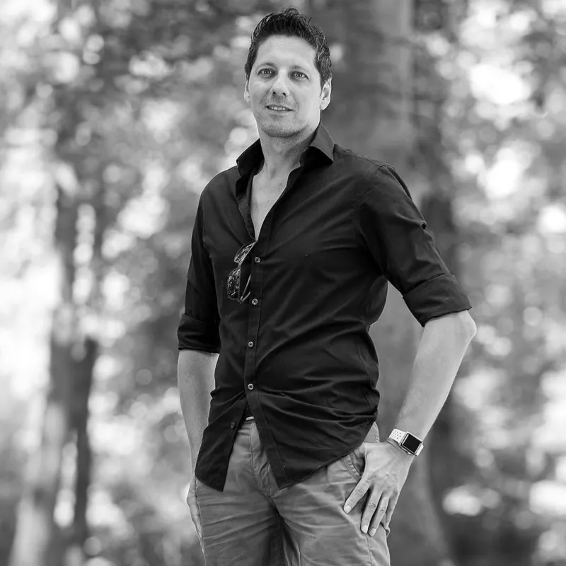 Schwarzweiß Portrait eines Mannes im dunklen Hemd mit Sonnenbrille am Kragen und Hand in der Hosentasche, Portraitfotograf Sömmerda Dirk Dittrich
